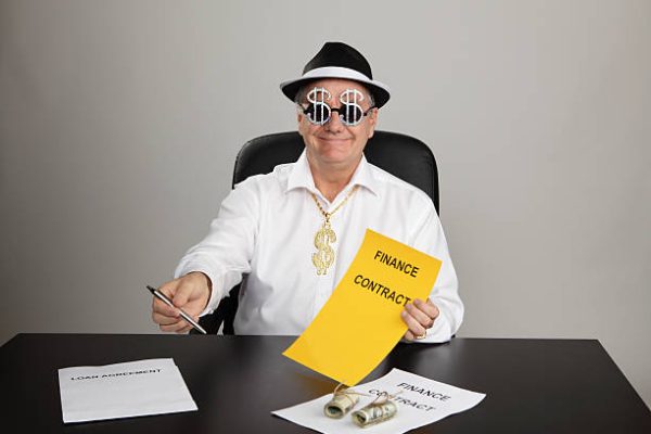 Shady businessman holding out pen and contract, with dollar-sign glasses and neckchain.